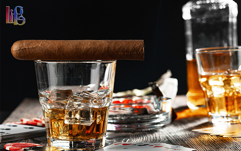 Cigar resting on a glass of whisky.